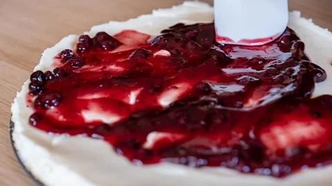 Preparing cheesecake with red syrup of red berries and strawberries with ch.. Stock Photos