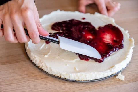 Preparing cheesecake with red syrup of red berries and strawberries with ch.. Stock Photos