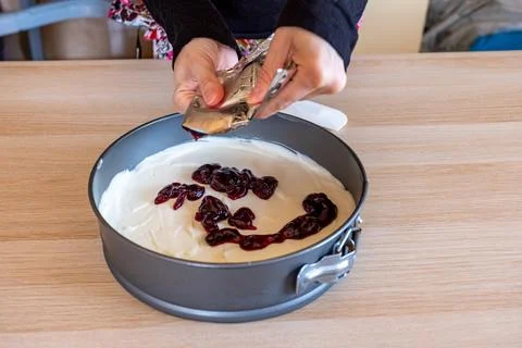 Preparing cheesecake with red syrup of red berries and strawberries with ch.. Stock Photos