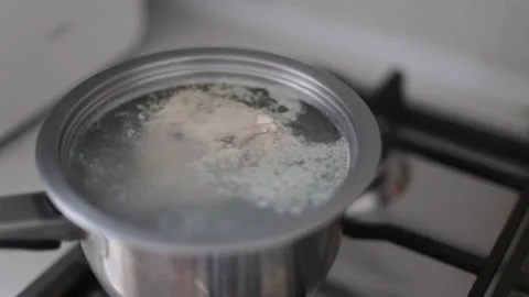 Preparing chicken broth for someone on a diet. A boiling pan on a gas stove with Stock-Footage 262422087