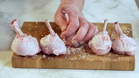Preparing chicken drumsticks for frying. Raw chicken legs sprinkled with spices. Stock Footage 240476647