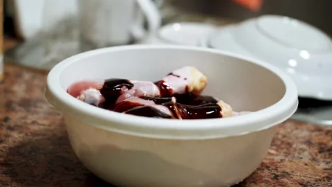 Preparing chicken legs for baking in a sauce in the kitchen Stock Footage 328904589
