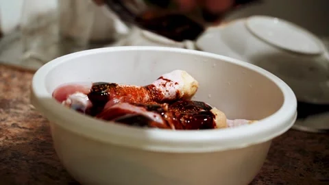 Preparing chicken legs for baking in a sauce in the kitchen Stock Footage 328904590