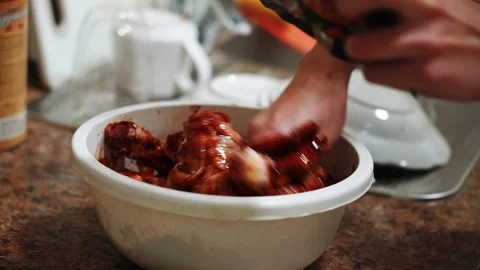 Preparing chicken legs for baking in a sauce in the kitchen Stock Footage 328904594
