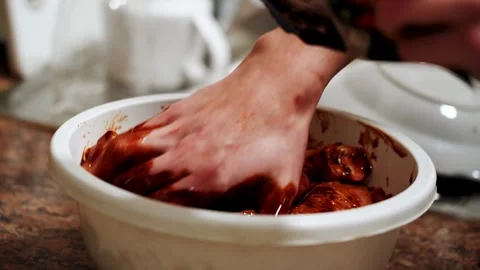 Preparing chicken legs for baking in a sauce in the kitchen Stock Footage 328904599