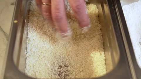Preparing chicken nuggets, coating chicken pieces in rolled in breadcrumbs. Stock Footage 239159851