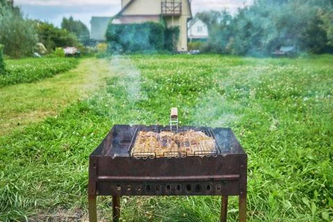 Preparing a chiken in a suburban area using a chairgrill and grill grid outd 写真素材