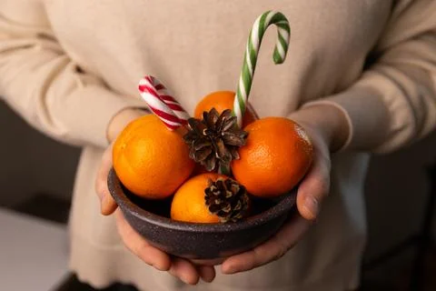 Preparing for Christmas With Oranges and Candy Canes in Hands Stock Photos