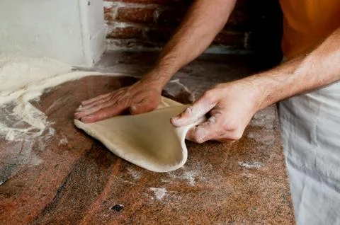 Preparing classical Pizza. Hands stretching the dough. Stock Photos