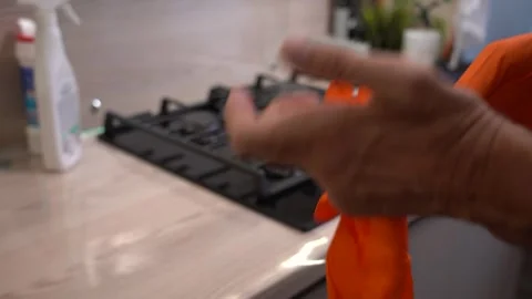 Preparing for Cleaning: A Person Puts On Bright Orange Gloves Before Engaging in Stock Footage 321051278