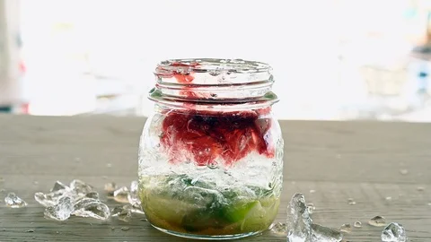 Preparing a cocktail long drink filled with red liquid  full of ice Stock Footage 108795850