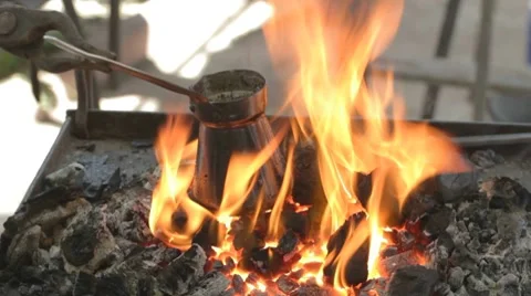 Preparing coffee in bronze pot outdoors on live coals Stock-Footage 7769213