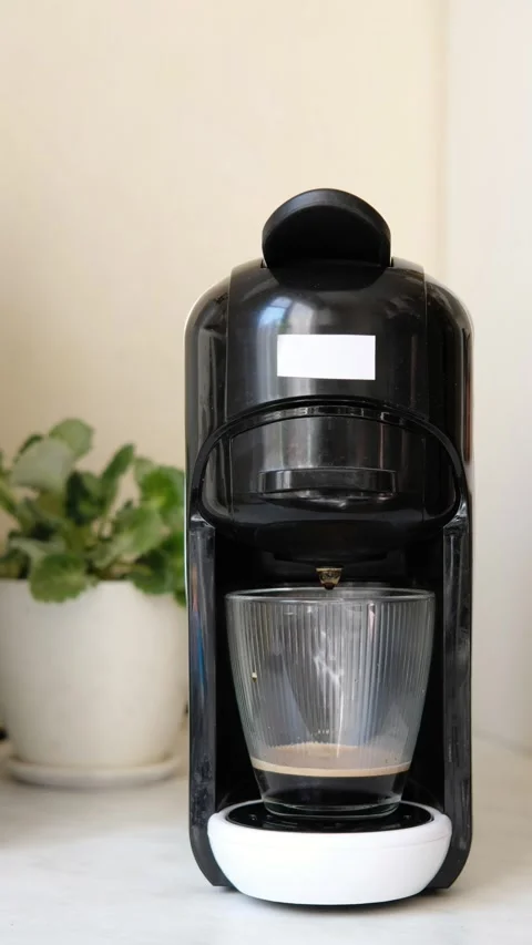 Preparing coffee from a capsule coffee machine into a transparent glass. Stock Footage 304821576