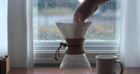 Preparing Coffee with a Chemex Filter and Grounds on a Rainy Day Stock Footage 100092302