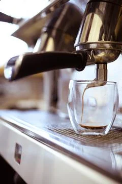 Preparing coffee machine pouring coffee in glass in cafe Stock Photos