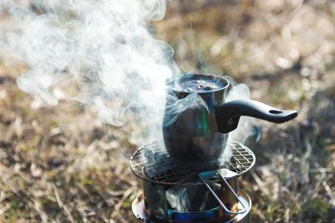 Preparing coffee in mountains. close up view of turkish coffee pot Stock Photos