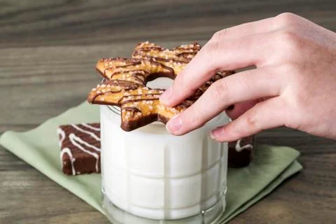 Preparing cookie for milk dip Stock Photos