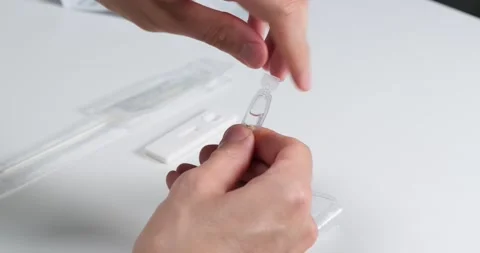 Preparing for Covid-19 rapid self test, pouring liquid into the tube. Stock Footage 155075013
