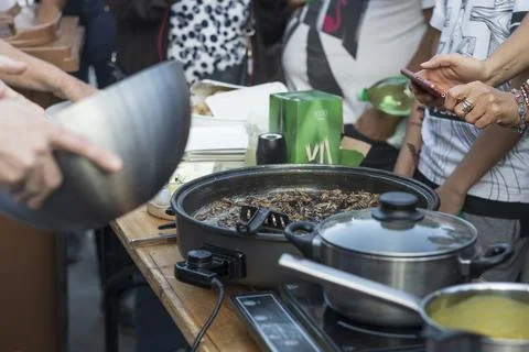 Preparing crickets in a pan for eating at a demonstration Stock Photos