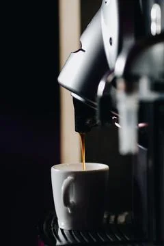 Preparing a cup of espresso coffee using a coffee machine. Stock Photos