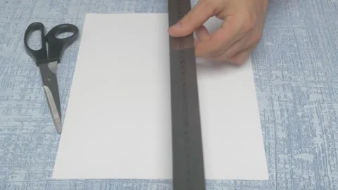 Preparing to cut paper using a ruler and a pair of scissors for a creative Stockbeeldmateriaal 283639392