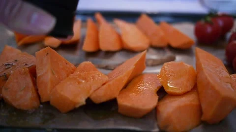 Preparing cut sweet potato for roasting with herbs oil and sea salt Stock Footage 147406455