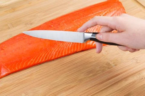 Preparing to cut wild red salmon for cooking Stock Photos