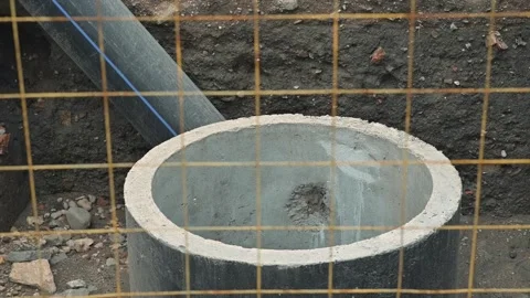 Preparing cylindrical concrete molds at a construction site. Materials are 库存影片 344675477