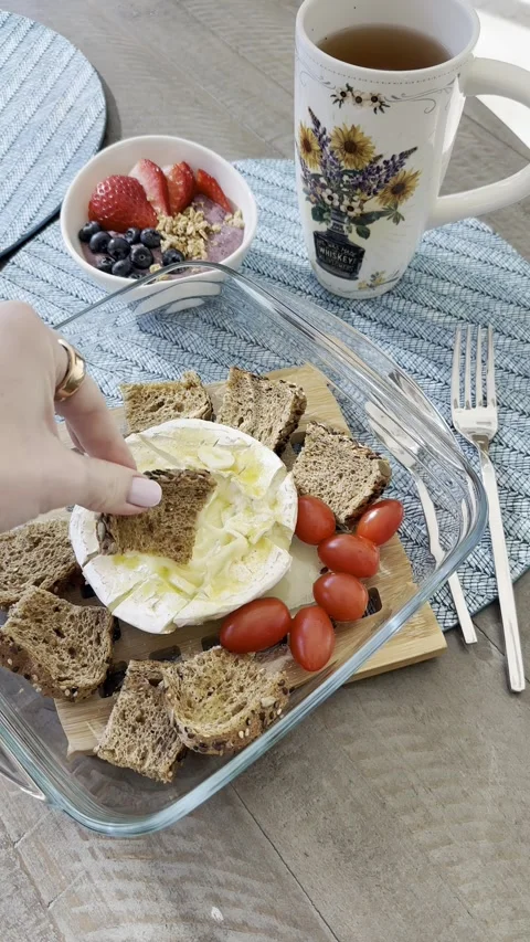 Preparing delicious cheese platter: adding honey to brie with fresh fruits Stock Footage 318553278