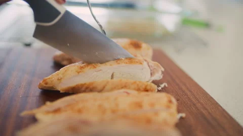 Preparing delicious cooked chicken by cutting into smaller pieces on a board Stock Footage 310242509
