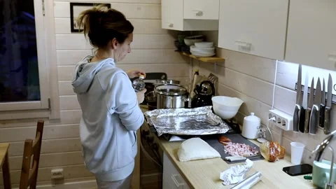 Preparing a delicious meal in a cozy kitchen with fresh ingredients and careful Stock Footage 306084738