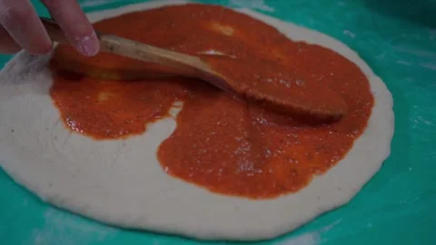 Preparing a Delicious Pizza Serving Sauce with Passion Stock Footage 293369379