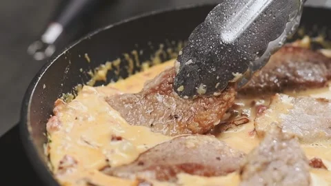 Preparing of delicious pork with sun-dried tomatoes in the frying pan. Stock Footage 154939162