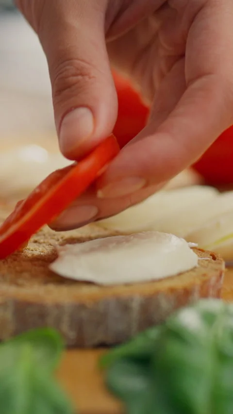 Preparing a delicious sandwich with fresh ingredients on a wooden cutting bo Stock Footage 331720116