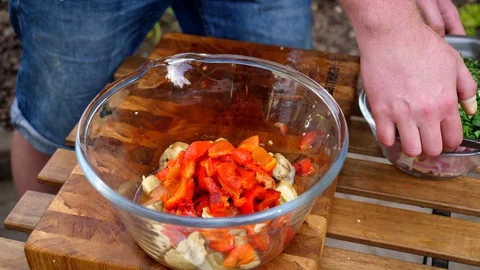 Preparing a delicious side dish of vegetables and herbs for a pork barbecue Video stock 128921141