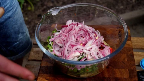 Preparing a delicious side dish of vegetables and herbs for a pork barbecue Stock Footage 128921594