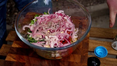 Preparing a delicious side dish of vegetables and herbs for a pork barbecue Stock Footage 128921658