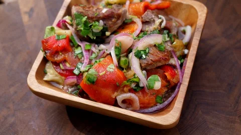 Preparing a delicious side dish of vegetables and herbs for a pork barbecue Stock Footage 128949250