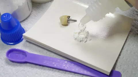 Preparing dental cement next to a false / artificial tooth implant. Stock Footage 171386149
