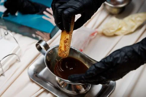 Preparing dessert by dipping biscuit in chocolate Stock Photos