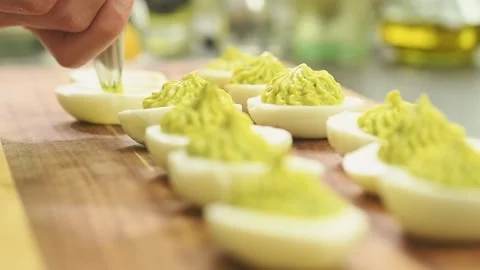 Preparing deviled eggs with avocado and basil. Stock Footage 165616399