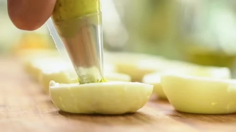 Preparing deviled eggs with avocado and basil. Video stock 165616417
