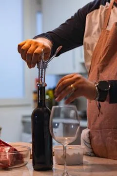 Preparing dinner opening wine bottle with a corkscrew Stock Photos