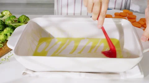 Preparing the dish by spreading olive oil for even roasting. Video stock 308159811
