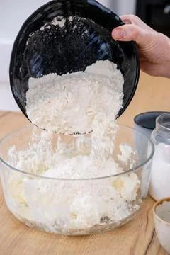 Preparing dough adding flour chef hand bowl whisk Stock-Fotos