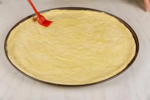 Preparing dough for making round pizza. Stock Photos