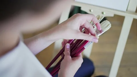 Preparing for drawing. Different brushes in women's hands close-up Stock Footage 156497102