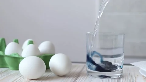 Preparing dye for dyeing eggs for Easter, pouring boiling water over the dye Stock Footage 149050166