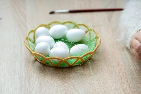 Preparing for Easter celebration painting eggs in basket on wooden table Stock Photos