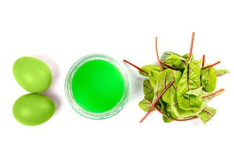 Preparing for easter, coloring eggs in green color with beet leaves Stock Photos